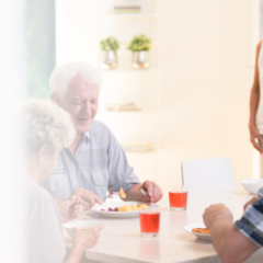 A group of seniors sitting at a table talking and laughing.